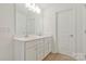 Bright bathroom featuring double sinks, white cabinets and a large mirror with modern lighting at 14224 Canemeadow Dr, Charlotte, NC 28278