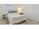 Cozy bedroom featuring a comfortable bed with a gray headboard, complemented by a chair and natural light at 14224 Canemeadow Dr, Charlotte, NC 28278