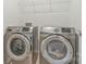Modern laundry room featuring stainless steel washer and dryer units with overhead wire shelf for storage at 14224 Canemeadow Dr, Charlotte, NC 28278