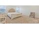 Primary bedroom with a cream colored bed, a small bedside table, natural light and carpeted floors at 14224 Canemeadow Dr, Charlotte, NC 28278