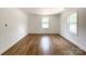 Spacious bedroom with wood floors, bright with natural light from two windows and white walls at 171 Three Cs Rd, Kershaw, SC 29067
