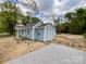 Light blue single-story home featuring vinyl siding, white trim, and a gravel parking area at 171 Three Cs Rd, Kershaw, SC 29067