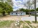Quaint light-blue home with a well-kept lawn, stone pathway, and large tree shading the gravel parking area at 171 Three Cs Rd, Kershaw, SC 29067