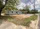 Charming single-story home with light blue siding and a gravel driveway under the shade of mature trees at 171 Three Cs Rd, Kershaw, SC 29067