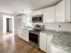 Modern kitchen featuring stainless steel appliances, granite countertops, and white cabinets at 171 Three Cs Rd, Kershaw, SC 29067