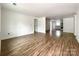 Bright, open-concept living space with wood-look floors leading to kitchen with stainless steel appliances at 171 Three Cs Rd, Kershaw, SC 29067