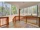 Covered porch with wood railing and ceiling overlooking the wooded backyard at 176 Forest Creek Dr, Statesville, NC 28625
