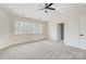 A bedroom with a ceiling fan, light walls, carpeted floors, and a large double window overlooking the woods at 176 Forest Creek Dr, Statesville, NC 28625