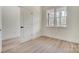 An empty bedroom with a double window, light walls, trim, baseboards, and wood-look flooring at 176 Forest Creek Dr, Statesville, NC 28625