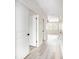 A bright hallway featuring crisp white doors, baseboards, light walls, and light wood-look flooring at 176 Forest Creek Dr, Statesville, NC 28625