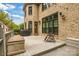 A spacious backyard features an outdoor patio and a large brick home with black trim windows in a serene, tree-filled setting at 18618 Rollingdale Ln, Davidson, NC 28036