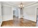 Spacious dining room with classic wainscoting, elegant chandelier, and an open doorway to the living area at 18618 Rollingdale Ln, Davidson, NC 28036