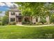 Charming two-story brick home with a well-manicured lawn, lush landscaping, and a welcoming entrance at 18618 Rollingdale Ln, Davidson, NC 28036