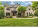 Stunning brick home with beautiful landscaping, a manicured lawn, and a charming entrance with columns at 18618 Rollingdale Ln, Davidson, NC 28036