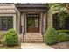 Close-up of the home's entrance, showcasing a beautiful brick facade, stately columns, and lush landscaping at 18618 Rollingdale Ln, Davidson, NC 28036
