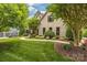 Beautifully landscaped front yard featuring a curved walkway leading to a charming brick home and detached garage at 18618 Rollingdale Ln, Davidson, NC 28036
