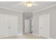 Hallway leading to the bonus room, with three doors, crown molding and carpet flooring at 18618 Rollingdale Ln, Davidson, NC 28036