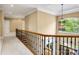 Upstairs hallway featuring iron railing overlooking the foyer and a decorative chandelier at 18618 Rollingdale Ln, Davidson, NC 28036