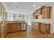 Spacious kitchen featuring wooden cabinets, stainless steel appliances, tile backsplash, and hardwood floors at 18618 Rollingdale Ln, Davidson, NC 28036