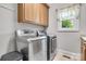 Laundry room with updated washer and dryer units, cabinets, and a window at 18618 Rollingdale Ln, Davidson, NC 28036