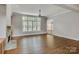 Bright living room featuring a stone fireplace, large windows, and hardwood flooring throughout at 18618 Rollingdale Ln, Davidson, NC 28036