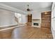 Inviting living room featuring a stone fireplace, built-in shelving, and easy access to the home's staircase at 18618 Rollingdale Ln, Davidson, NC 28036