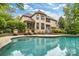 Beautiful pool with stone accents, surrounded by lounge chairs and manicured landscaping at 18618 Rollingdale Ln, Davidson, NC 28036