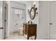 Stylish powder room featuring a decorative mirror, wood vanity, and tile flooring at 18618 Rollingdale Ln, Davidson, NC 28036