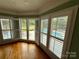 Bright bonus room with hardwood floors and views of the backyard pool and landscaping through shuttered windows at 1901 Benjamin Dr, Salisbury, NC 28146