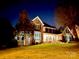 Stunning two-story brick home with a well-manicured lawn, lit by landscape lighting at twilight at 1901 Benjamin Dr, Salisbury, NC 28146