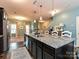 Open kitchen featuring a large island with granite countertop, sink, and bar stool seating at 20025 Metaphor Mews None, Davidson, NC 28036