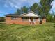 Charming brick home featuring a welcoming front porch and a spacious lawn at 2035 Mauney Rd, Bessemer City, NC 28016
