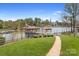 Lush backyard with a pathway leading to a dock with covered boat slips at 220 Chandeleur Dr, Mooresville, NC 28117