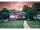 Brick home featuring a well-maintained lawn, a spacious deck, a brick walkway, and mature trees at 220 Chandeleur Dr, Mooresville, NC 28117