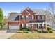 Traditional brick home with a two-car garage, manicured landscaping, front porch with rocking chairs at 220 Chandeleur Dr, Mooresville, NC 28117