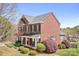 Brick home with lush landscaping, a covered front porch with rocking chairs, and a serene setting at 220 Chandeleur Dr, Mooresville, NC 28117