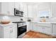 Bright, white kitchen with stainless steel appliances, tile backsplash, and a farmhouse sink at 220 Chandeleur Dr, Mooresville, NC 28117
