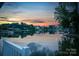 Scenic lake view featuring calm waters, mature trees, and stunning sunset colors, viewed from a porch at 220 Chandeleur Dr, Mooresville, NC 28117