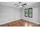 A bright bedroom featuring hardwood floors, a ceiling fan and two windows with tree views at 2200 Stratford Ave, Charlotte, NC 28205