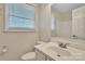 This well-lit bathroom features a white vanity, mirror, window with blinds, toilet, and light fixtures at 266 Kelly St, Statesville, NC 28677