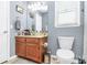 Bathroom featuring a light wood vanity, a large mirror, and a standard white toilet at 2703 Plantation Way, Albemarle, NC 28001