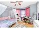 Bright bedroom with a canopy bed, pink and purple accents, and wood flooring at 2703 Plantation Way, Albemarle, NC 28001