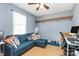 Bedroom with a ceiling fan, wood flooring, and a blue sectional with lots of natural light at 2703 Plantation Way, Albemarle, NC 28001