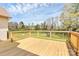 Spacious deck with wooden railings, overlooking a serene backyard with mature trees at 2703 Plantation Way, Albemarle, NC 28001