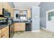 Well-lit kitchen with black appliances, wood cabinets, granite countertops and tile flooring at 2703 Plantation Way, Albemarle, NC 28001