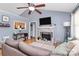 Bright living room with a brick fireplace, ceiling fan, and open view of the kitchen at 2703 Plantation Way, Albemarle, NC 28001