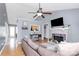 Open-concept living room with vaulted ceiling, fireplace, ceiling fan, and hardwood floors at 2703 Plantation Way, Albemarle, NC 28001