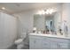 Bright bathroom featuring double sinks, a large mirror, and a shower behind a curtain at 2932 Pirates Pl, Charlotte, NC 28216