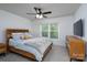 Bright bedroom featuring a wooden bed frame, ceiling fan, and large window with serene outdoor views at 2932 Pirates Pl, Charlotte, NC 28216