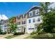 Townhouse exterior with colorful siding and a one-car garage, plus a neatly landscaped yard with shrubbery and tree at 2932 Pirates Pl, Charlotte, NC 28216